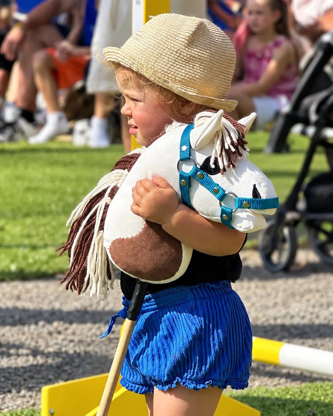 A young child embracing a hobby horse